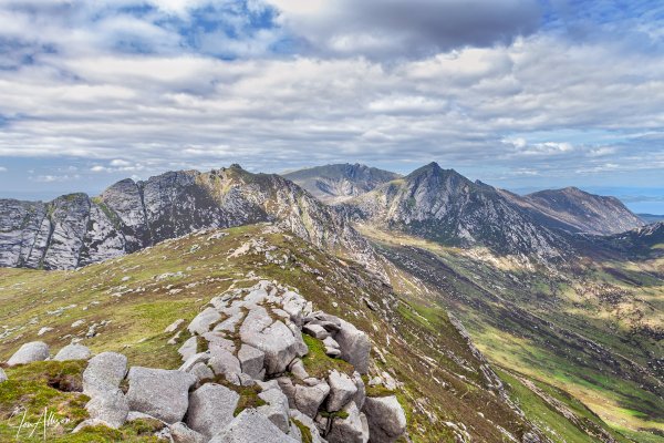An iconic picture looking along the approach ridge to the top of Beinn Tarsuinn, and onward to A'Chir, Cir Mhor and Caisteal Abhail in the distance. The coastline in the far distance is that of the Kintyre Peninsula. Pure magic.